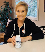 Load image into Gallery viewer, Person holding Pure Neuro brain supplement bottle by PureLife Organics – daily nootropic support for memory, clarity, and focus in a modern lifestyle setting